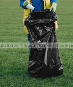 Người sử dụng túi rác công nghiệp khổ lớn để thu gom rác ngoài trời